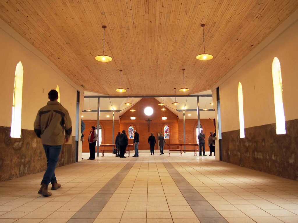 Interior looking down the nave towards the new sanctuary during construction, showing exposed trusses, no roof.
